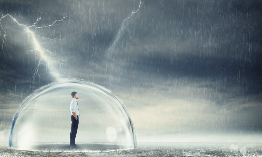 Businessman safely inside a sphere during a storm . Protection from the crisis concept